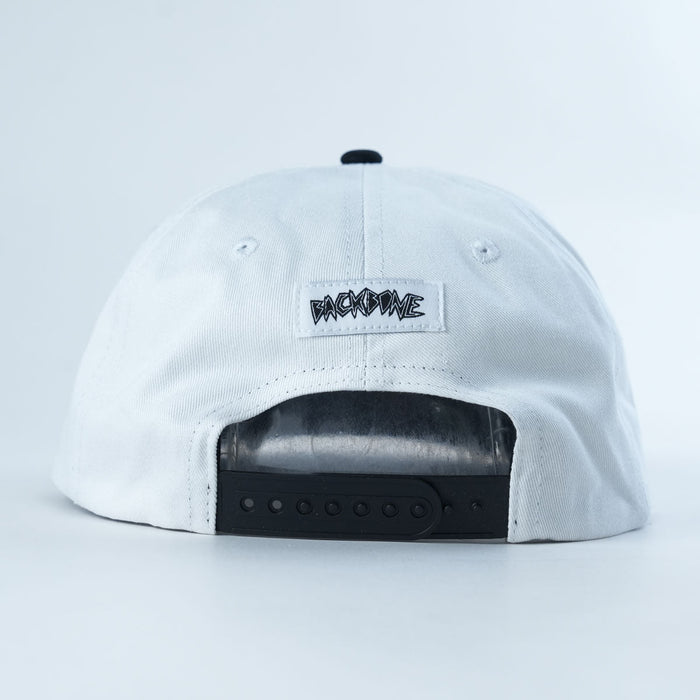 The Backbone Distance Snapback Hat is shown from the back, highlighting a black adjustable snapback closure and a small tag with stylized black “BACKBONE” text.
