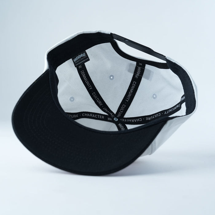 Inside view of the Backbone Distance Snapback Hat in black and white, featuring unstructured 5-panel construction with visible inner seams and the printed words “COMMUNITY CULTURE CHARACTER” on the sweatband.