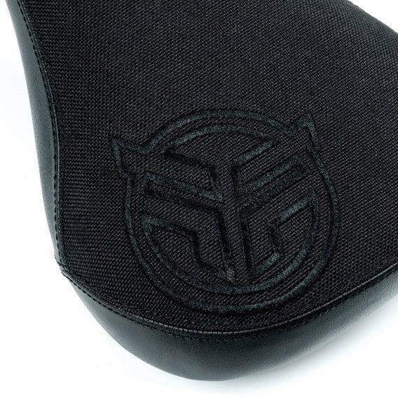 Close-up of the Federal Mid Stealth Logo Seat, showcasing its black canvas top, faux leather side panels, and black embroidered circular Federal logo—designed for durability and lasting performance.